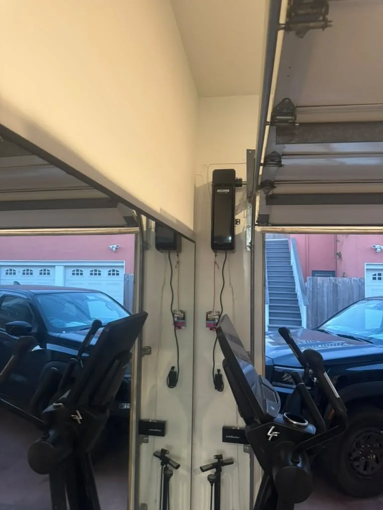 Wall-mount garage door openers installed beside the doors in an Encino garage